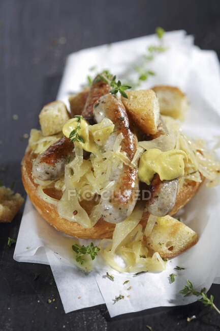 Salsicce di Norimberga con senape e crauti su un panino — Foto stock