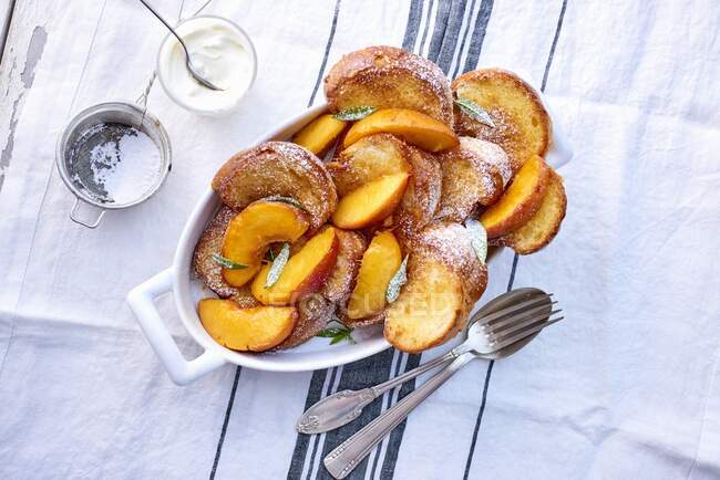 Pain perdu dessert with peaches in sugar powder — Stock Photo