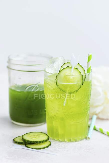 Cucumber icy alcohol drink in glass and smoothie in jar — Stock Photo
