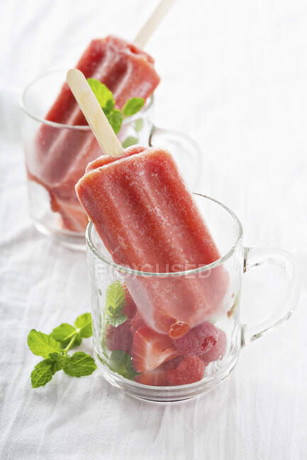 Strawberry ice lollies served with berries in glass cups — Stock Photo