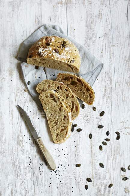 Тыквенный хлеб с семенами и ножом на деревянной поверхности — стоковое фото