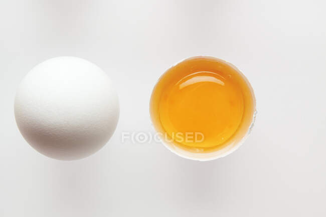 Huevos blancos, uno abierto - foto de stock