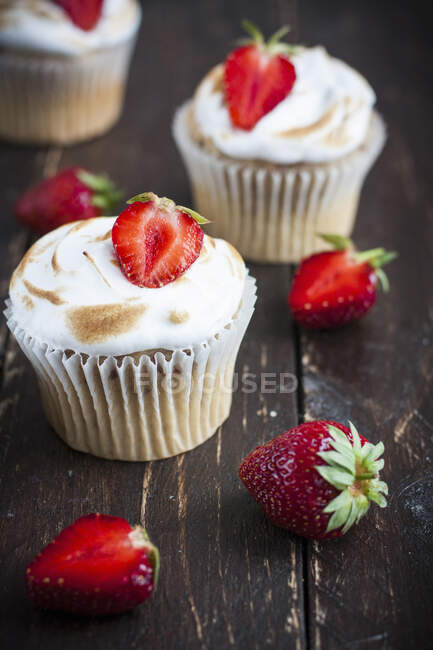 Merengues rematado Cupcakes con fresas frescas - foto de stock