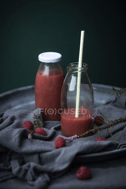 Raspberry smoothies in glass bottles — Stock Photo