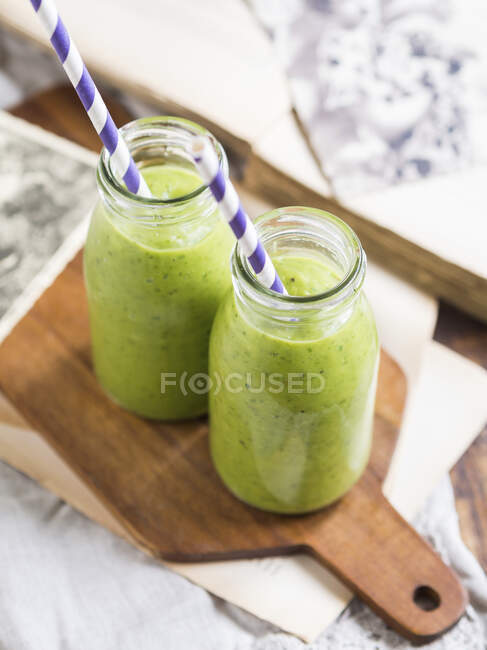 Зеленый веганский смузи в двух маленьких бутылочках — стоковое фото