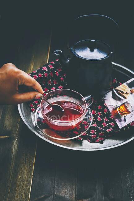 Teapot and glass-top with herbal tea on tray — Stock Photo