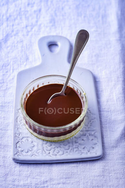 Chocolate and vanilla layered dessert in mini glass jar with spoon — Stock Photo