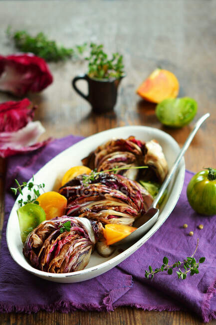 Fried radicchio with fresh tomatoes and herbs in bowl — Stock Photo