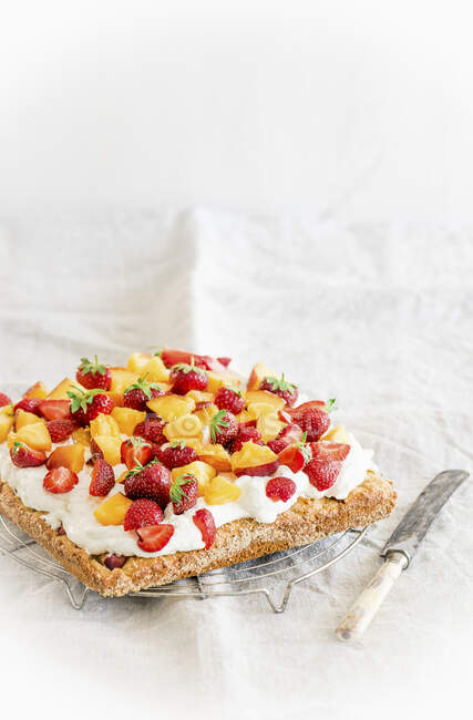 Peach and strawberry cake with mascarpone curd cream on a marzipan base — Stock Photo