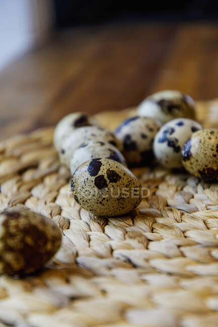 Quail eggs on woven coaster at table — Stock Photo