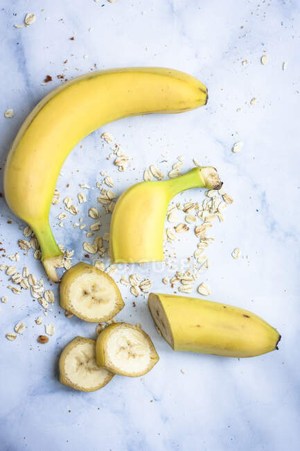 Una banana intera e una banana affettata con avena — Foto stock