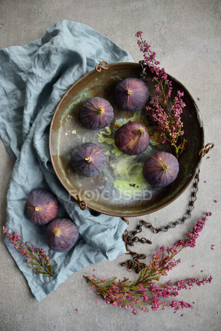 Figos frescos em placa de metal rústico com flores secas e pano — Fotografia de Stock