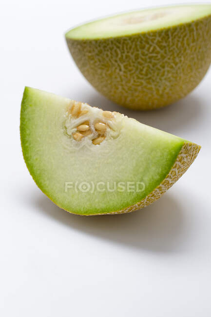 A half and a quarter of a honeydew melon — Stock Photo