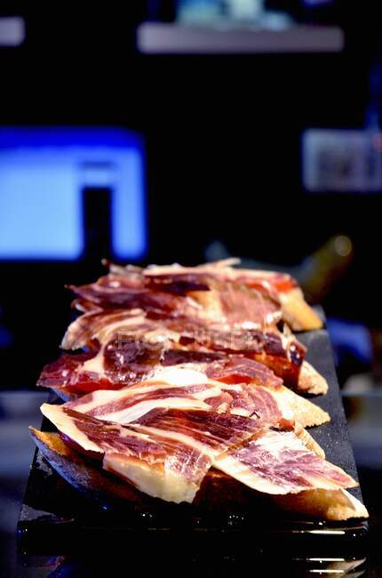 Crostini with Iberian ham on a bar — Stock Photo