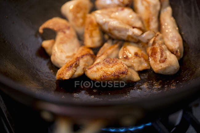 Sauting chicken in a wok close-up view — Stock Photo