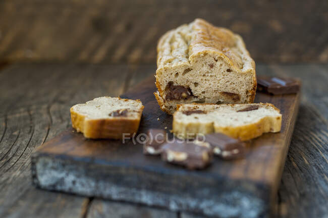 Pane alla banana con cioccolato, affettato su una tavola di legno — Foto stock