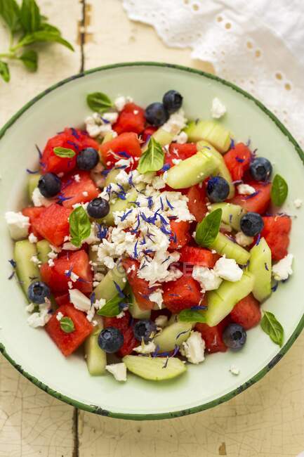 Watermelon salad with blueberries, feta, cucumber, basil and cornflower blossoms — Stock Photo