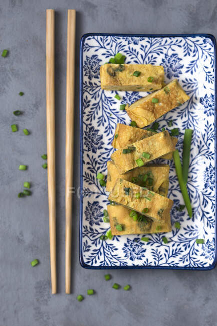 Giapponese arrotolato frittata Tamagoyaki con erba cipollina fresca — Foto stock