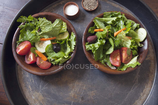 Зеленый салат из листьев в деревянных чашках — стоковое фото