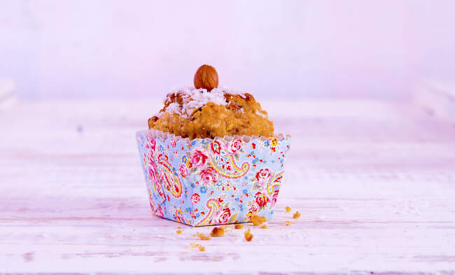 Un muffin à la noix de coco dans un étui en papier coloré — Photo de stock
