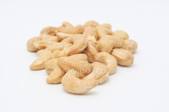 Salted cashews on a white surface — Stock Photo
