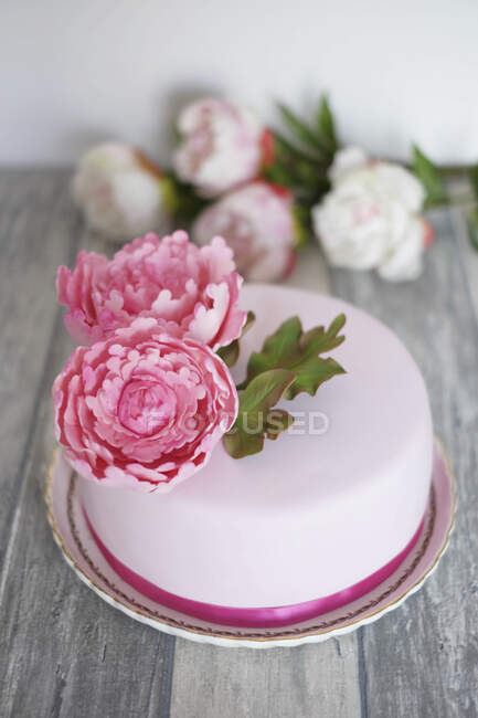Una torta fondente decorata con peonie — Foto stock