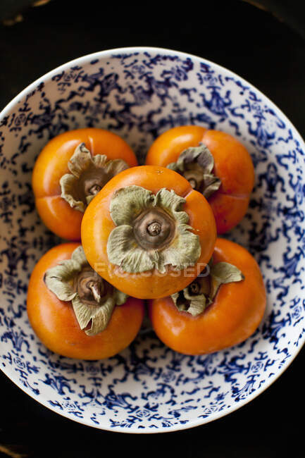 Five persimmons in a bowl — Stock Photo