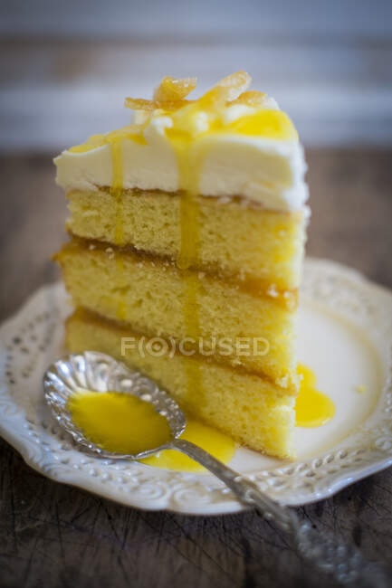 Una rebanada de pastel de limón de tres capas con glaseado - foto de stock
