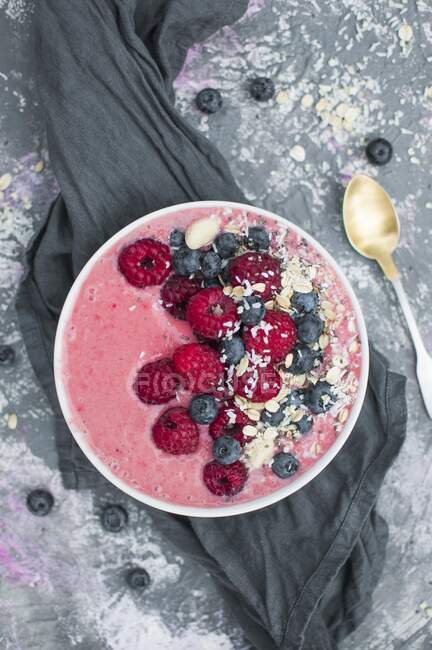 Strawberry smoothie bowl with yoghurt, raspberries, blueberries, oats and coconut flakes — Stock Photo