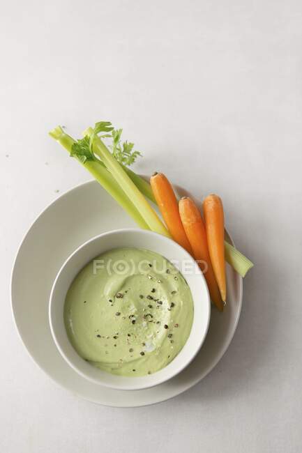 A tahini and coriander dip with pepper, sea salt flakes and carrot and celery sticks — Stock Photo