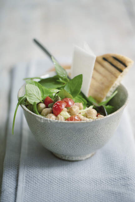 Chickpea salad with tomatoes, basil and unleavened bread — Stock Photo