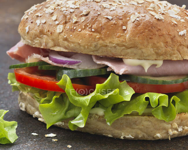 Un sandwich al prosciutto con insalata, cipolla, pomodoro e maionese — Foto stock