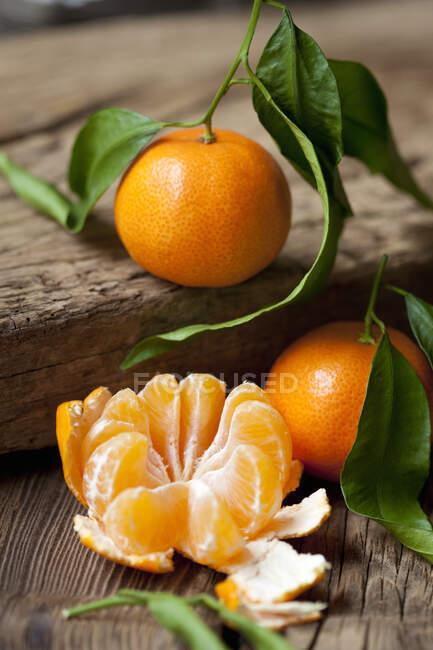 Mandarinas ecológicas, enteras y peladas - foto de stock