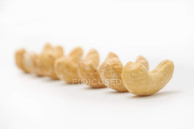 Roasted and salted cashews in a row — Stock Photo