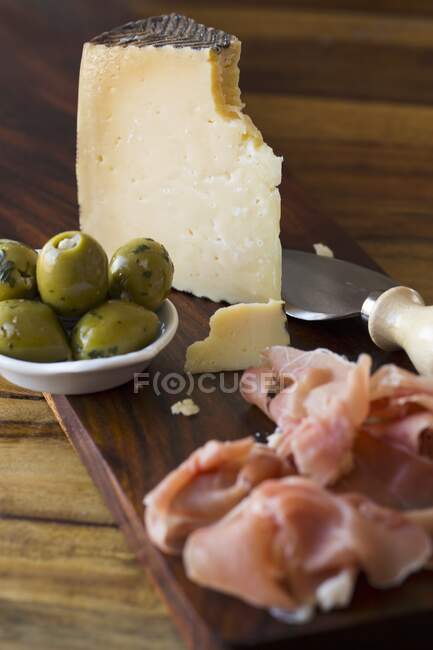 Manchego Käse mit Oliven und Serrano Schinken — Stockfoto