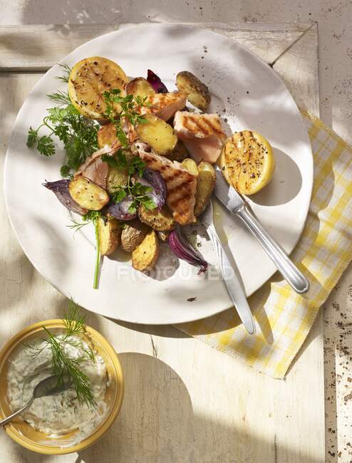 Pollo al horno con patatas y verduras en un plato blanco - foto de stock