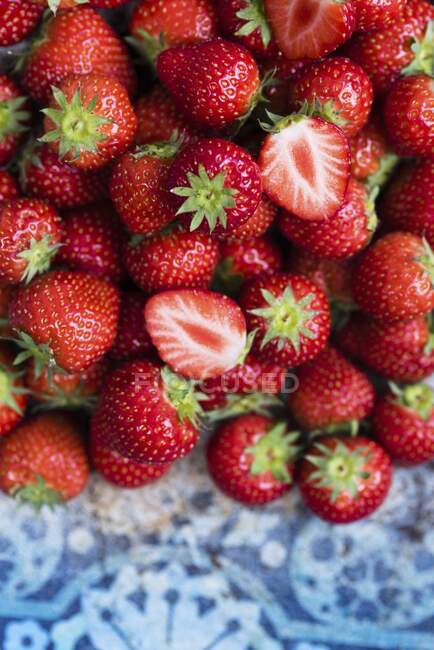 Frische Erdbeeren stapeln sich auf blau verzierten Fliesen, Nahaufnahme — Stockfoto