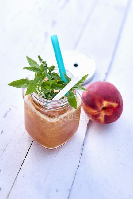 Peach smoothie on white wood — Stock Photo