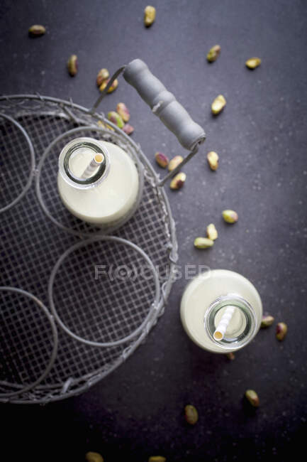 Homemade pistachio milk with straws in bottles (top view) — Stock Photo