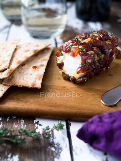 Date dotted goat cheese log on cheese board — Stock Photo