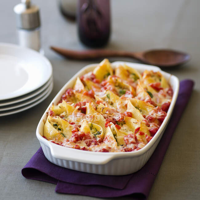 Shell pasta with cheese and vegetables filling in baking dish — Stock Photo