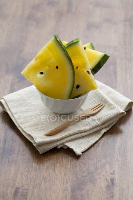 Morceaux de pastèque jaune dans un bol sur une serviette — Photo de stock