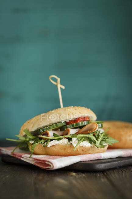 Bagel-Sandwich mit geräucherter Putenbrust, Rucola und Gurken — Stockfoto