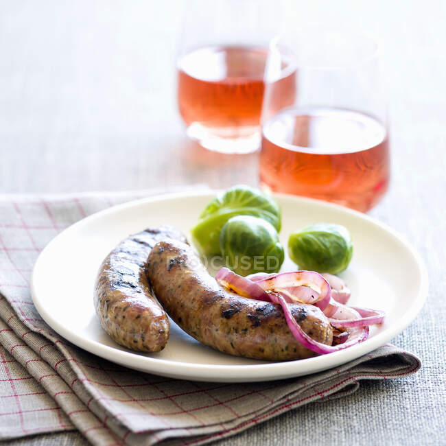 Sausages with red onions and Brussels sprouts — Stock Photo