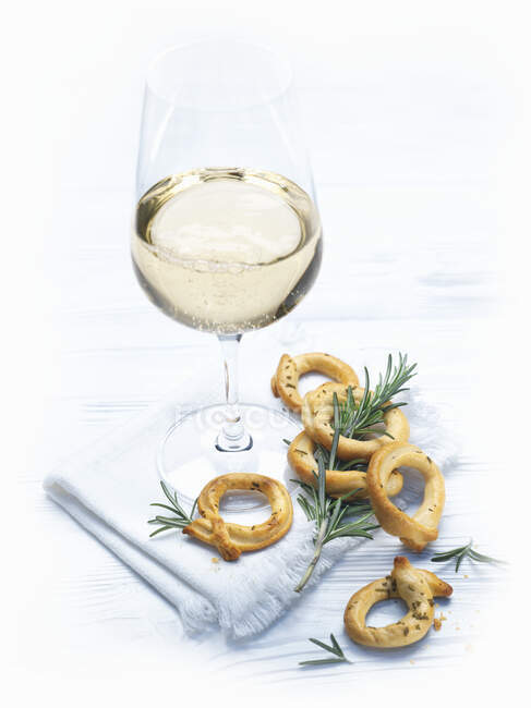 Taralli Pugliese y una copa de vino blanco - foto de stock