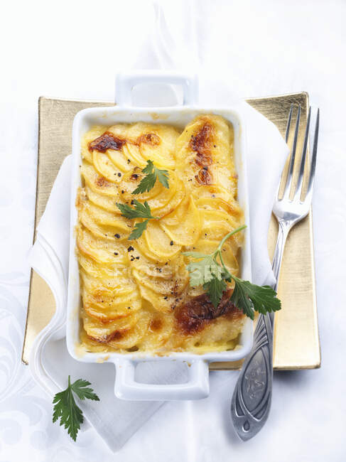 Truffle and potato gratin with parsley in tin — Stock Photo