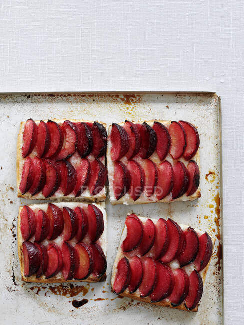 Buttered plums puddings on metal tin — Stock Photo