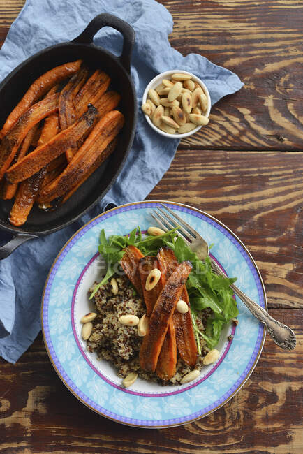 Cenouras inteiras assadas servidas com quinoa e amêndoas — Fotografia de Stock