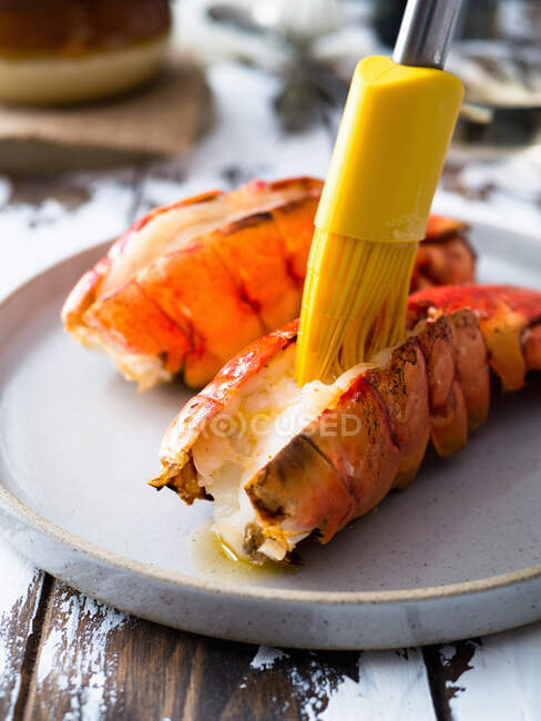 Melting butter on broiled lobster tails — Stock Photo