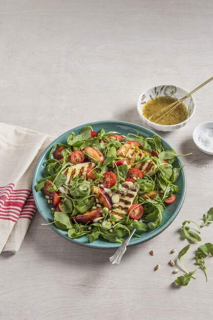 Grilled halloumi salad with grilled apricots, pine nuts, tomatoes and honey mustard dressing — Stock Photo